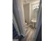 A view into the powder room with new wood look floors, pedestal sink, and round mirror at 3731 Patti Pkwy, Decatur, GA 30034