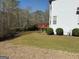 Landscaped backyard featuring a well-maintained lawn with a deck in the background and mature trees at 711 Lily Glen Ln, Stockbridge, GA 30281