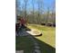 Spacious backyard with lush lawn, a stone fire pit, a deck and privacy from mature trees at 711 Lily Glen Ln, Stockbridge, GA 30281