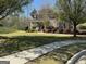 Landscaped home exterior with healthy yard, mature shade trees, and sidewalk access at 711 Lily Glen Ln, Stockbridge, GA 30281