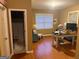 Home office with wood floors, a window, and access to a bathroom at 711 Lily Glen Ln, Stockbridge, GA 30281