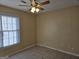 Neutral bedroom features a ceiling fan, tile flooring, and window providing natural light at 634 S Jeff Davis Dr, Fayetteville, GA 30215