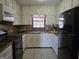The kitchen features white cabinets, black appliances, a tile backsplash, and a window at 634 S Jeff Davis Dr, Fayetteville, GA 30215