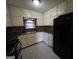 The kitchen features white cabinets, black appliances, tile floors, and a window at 634 S Jeff Davis Dr, Fayetteville, GA 30215