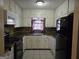 The kitchen features white cabinets, black appliances, tile floors, and a window at 634 S Jeff Davis Dr, Fayetteville, GA 30215