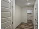 Hallway with wood-look floors leading to the laundry room with white cabinets at 22638 Salem Church Rd, Metter, GA 30349