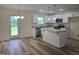 Open kitchen with white cabinets, stainless appliances, granite countertops, and eat-in island at 22638 Salem Church Rd, Metter, GA 30349