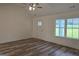 Open-concept living room with ceiling fan, wood-look floors, and a view of the outdoors at 22638 Salem Church Rd, Metter, GA 30349