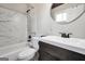 This bathroom features a sink, vanity, toilet and shower with marble tile at 509 Eskew Rd, Mcdonough, GA 30252