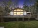 Charming home featuring a large deck and expansive windows, creating a welcoming facade at dusk at 509 Eskew Rd, Mcdonough, GA 30252