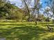 Large, grassy backyard featuring mature trees, a swing set, and an old chair at 1202 Coan Dr, Locust Grove, GA 30248