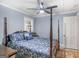Comfortable bedroom featuring a four-poster bed with blue floral bedding and a ceiling fan at 1202 Coan Dr, Locust Grove, GA 30248