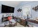 Bedroom with a wall-mounted TV, desk, and carpeted floors at 1202 Coan Dr, Locust Grove, GA 30248