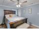 Cozy bedroom featuring a comfortable bed, a modern ceiling fan, and natural light at 1202 Coan Dr, Locust Grove, GA 30248