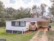 Charming home with covered carport, landscaping and a 'Welcome' sign near the front porch at 1202 Coan Dr, Locust Grove, GA 30248