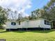 Backside of the home with tidy siding and a well-maintained lawn on a sunny day at 1202 Coan Dr, Locust Grove, GA 30248
