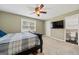 Bedroom with carpeted floors, neutral walls, ceiling fan, large window, and ensuite bathroom entrance at 280 Nutt Dr, Locust Grove, GA 30248