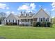 Charming home featuring a well-manicured lawn and inviting front porch with black shutters and a detached garage at 280 Nutt Dr, Locust Grove, GA 30248