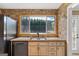 A kitchen sink and cabinetry are framed by a window that overlooks trees and is surrounded by stone accent walls at 280 Nutt Dr, Locust Grove, GA 30248