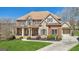 Stunning two-story brick home featuring a welcoming front porch, manicured lawn, and stone accents at 3149 Hidden Falls Ne Dr, Buford, GA 30519