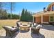 Outdoor fire pit with comfortable seating, perfect for entertaining on a well-maintained brick patio and landscaped yard at 3149 Hidden Falls Ne Dr, Buford, GA 30519