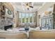 Warm living room featuring a stone fireplace, a coffered ceiling, large windows, and cozy armchairs at 3149 Hidden Falls Ne Dr, Buford, GA 30519