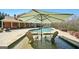 Backyard pool with a large sun umbrella over in-water lounge chairs, set in a beautifully landscaped outdoor area at 3149 Hidden Falls Ne Dr, Buford, GA 30519