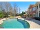 Luxury home features a kidney-shaped pool, stone patio, and outdoor lounge area at 3149 Hidden Falls Ne Dr, Buford, GA 30519