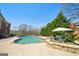 Beautiful backyard with a kidney-shaped pool, lounge chairs, mature trees and landscaping at 3149 Hidden Falls Ne Dr, Buford, GA 30519