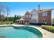 Relaxing pool with an outdoor seating area and exterior view of home under a beautiful sunny sky at 3149 Hidden Falls Ne Dr, Buford, GA 30519