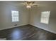 Bedroom with wood floors, two windows with blinds, and a ceiling fan at 103 Greenwood Dr, Stockbridge, GA 30281