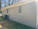 Exterior side view of a brick home with an AC unit and basement access at 103 Greenwood Dr, Stockbridge, GA 30281