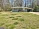 Single-story home with a gray brick exterior, shutters, and a large front yard at 103 Greenwood Dr, Stockbridge, GA 30281