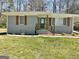 Charming gray brick home featuring stylish wooden shutters and a quaint front porch at 103 Greenwood Dr, Stockbridge, GA 30281