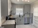 Well-lit kitchen with gray cabinets, granite countertops, and modern stainless steel appliances at 103 Greenwood Dr, Stockbridge, GA 30281