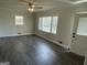 Living room with wood floors, multiple windows with blinds, and a white door at 103 Greenwood Dr, Stockbridge, GA 30281