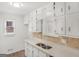 Galley kitchen with white cabinets, laminate countertops with tile backsplash, and stainless steel sink at 117 Spring St, Stockbridge, GA 30281
