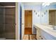 Bathroom with a single sink vanity, walk-in shower, and view of bedroom with hardwood floors at 132 Westmont Way, Tyrone, GA 30290