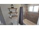 Bathroom with tub and shower, wood-look tile, decorative shelves, and neutral color scheme at 1901 E Farris Ave, East Point, GA 30344