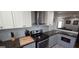 Modern kitchen with stainless steel range hood and appliances, accented by gray lower cabinets and countertops at 1901 E Farris Ave, East Point, GA 30344