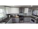 Well-lit kitchen with stainless steel appliances, white upper cabinets, and light gray lower cabinets at 1901 E Farris Ave, East Point, GA 30344