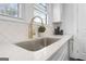 Kitchen featuring quartz countertops, white cabinetry, and a stainless steel sink at 2377 Beecher Sw Rd, Atlanta, GA 30311