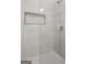 Modern shower with white marble tile, glass doors, and inset shower niche at 2377 Beecher Sw Rd, Atlanta, GA 30311