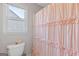 Cozy bathroom features a toilet next to a window and ruffled pink shower curtain at 3967 Bellingrath Main Nw, Kennesaw, GA 30144