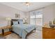 Comfortable bedroom with soft blue bedding, complemented by warm wood furniture and natural light at 3967 Bellingrath Main Nw, Kennesaw, GA 30144