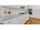 A modern kitchen features white cabinets, granite countertops, stainless steel appliances, and a stylish subway tile backsplash at 3967 Bellingrath Main Nw, Kennesaw, GA 30144