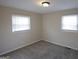 This bedroom features neutral walls, carpeted floors, and natural light from two windows at 263 Banberry Se Dr, Atlanta, GA 30315