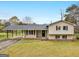 Charming single-story home boasts a covered carport and inviting front porch, surrounded by a well-manicured lawn at 71 Russell Rd, Mcdonough, GA 30252
