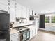 Charming kitchen featuring white cabinets, appliances, tile backsplash, and natural light at 71 Russell Rd, Mcdonough, GA 30252