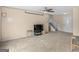 Bright living room with neutral carpet, ceiling fan, stairs leading to a second floor, and entry door at 71 Russell Rd, Mcdonough, GA 30252